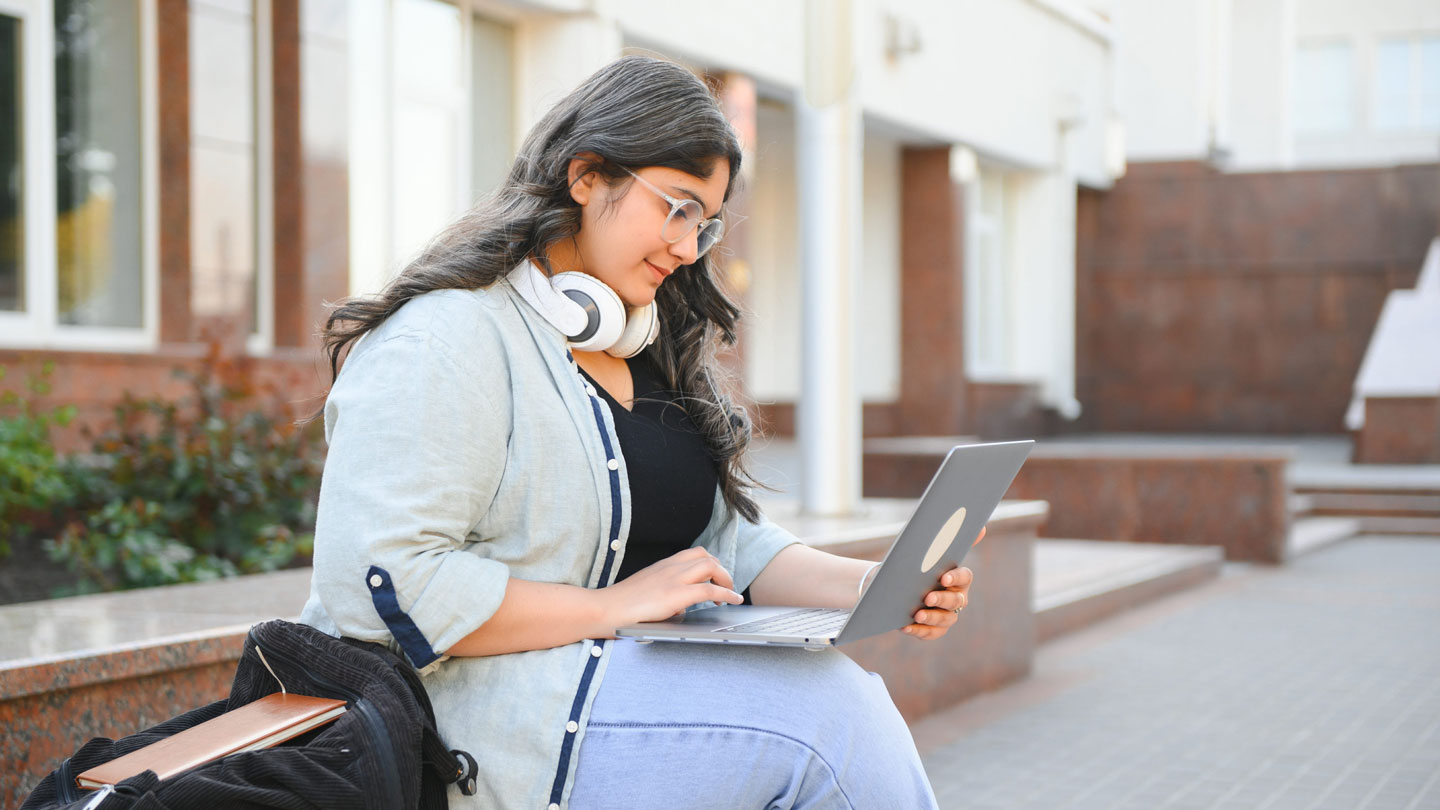 Student studying for English exam with laptop